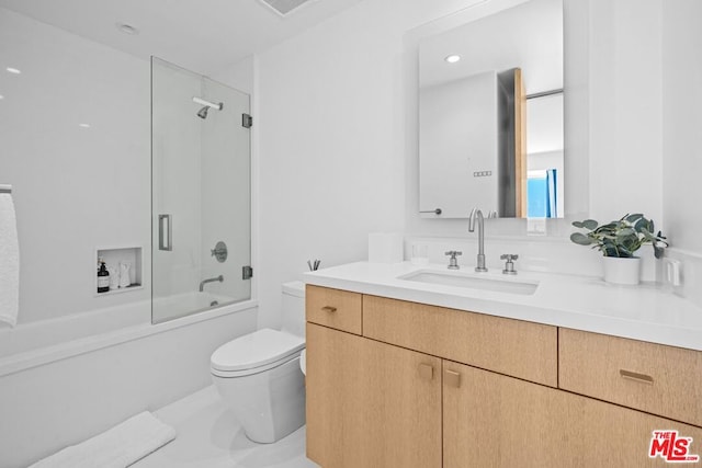 full bathroom featuring vanity, bath / shower combo with glass door, and toilet