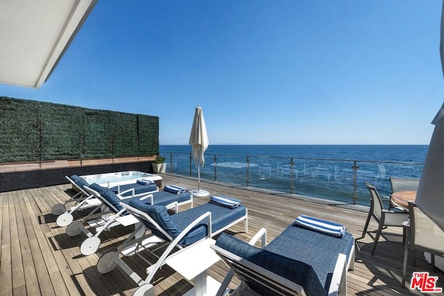 wooden terrace featuring a jacuzzi and a water view