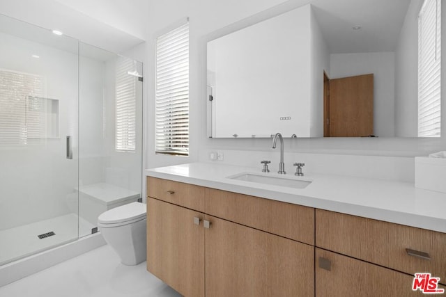 bathroom with vanity, toilet, and a shower with door