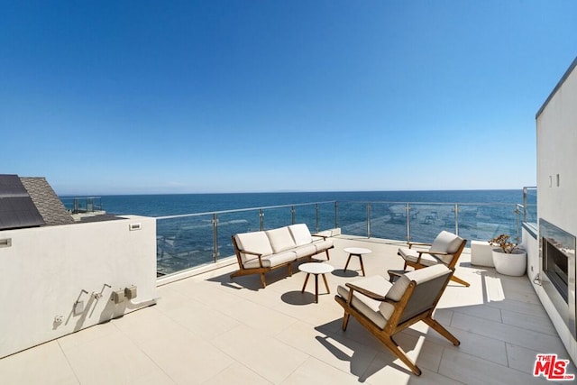 view of patio with a balcony, a water view, and outdoor lounge area