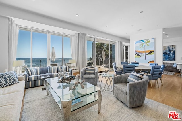 living room featuring a water view and light hardwood / wood-style flooring