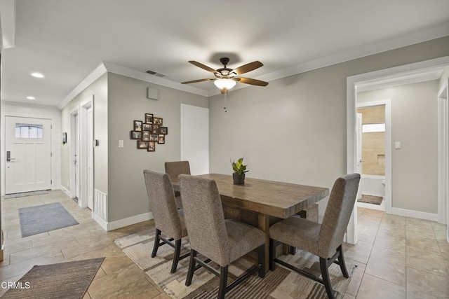 dining area with crown molding and ceiling fan