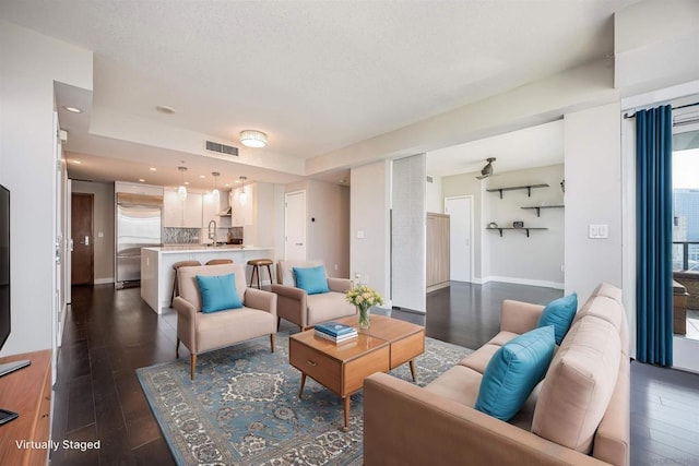 living room with dark hardwood / wood-style flooring and sink