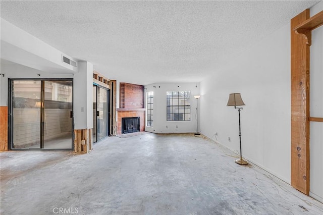 unfurnished living room with a fireplace and a textured ceiling