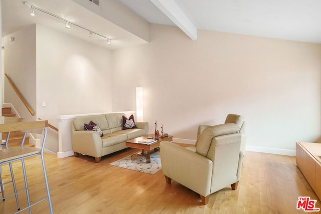 living room featuring lofted ceiling with beams and light hardwood / wood-style floors