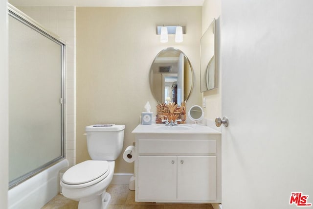 full bathroom featuring vanity, tile patterned floors, combined bath / shower with glass door, and toilet