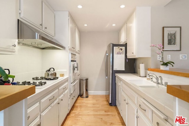 kitchen featuring sink, white cabinets, decorative backsplash, tile counters, and white appliances