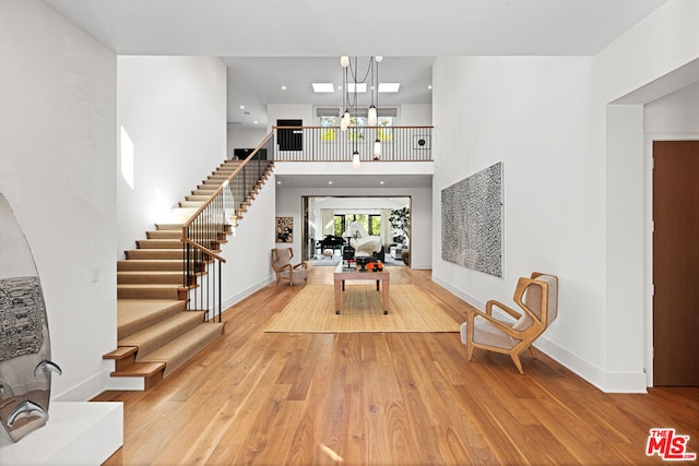 entryway featuring a towering ceiling and light hardwood / wood-style flooring