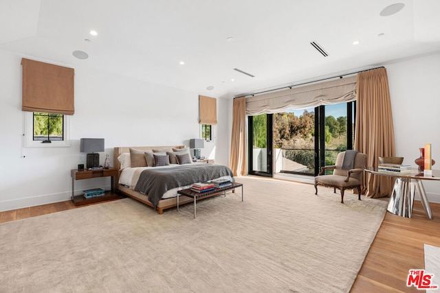 bedroom featuring multiple windows, access to outside, and light wood-type flooring