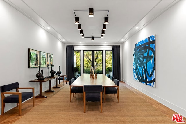 dining area featuring crown molding and light hardwood / wood-style flooring