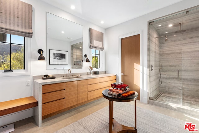 bathroom with tile patterned flooring, vanity, and walk in shower