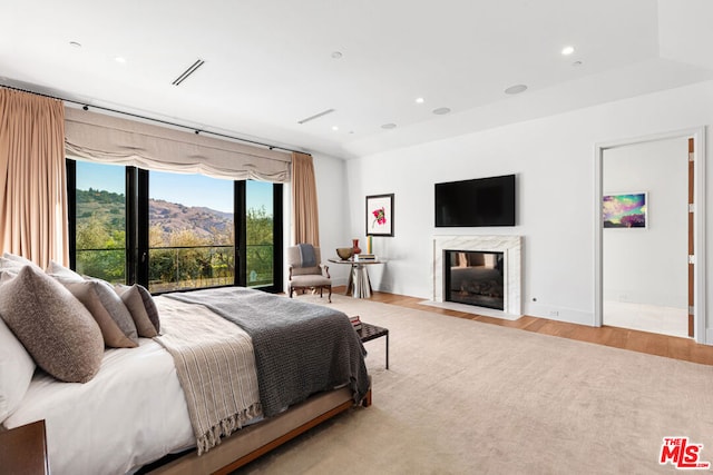 bedroom featuring a fireplace and light hardwood / wood-style floors