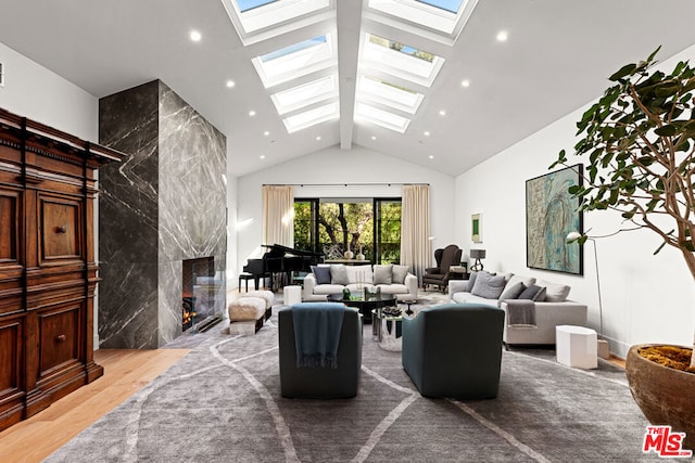 living room featuring a skylight, high vaulted ceiling, beamed ceiling, a fireplace, and hardwood / wood-style floors