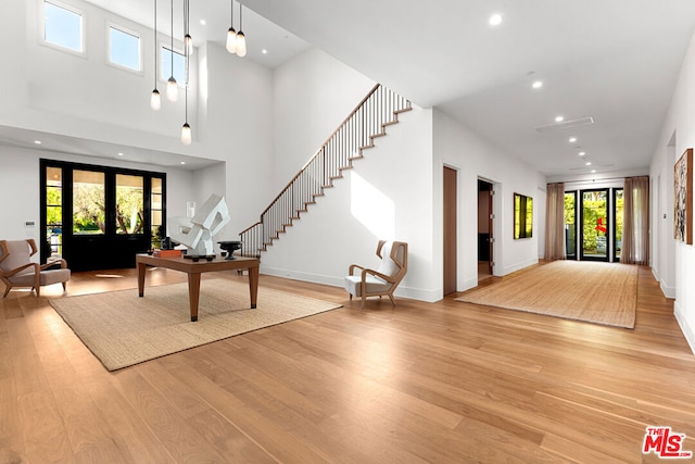 foyer with french doors, a high ceiling, and light hardwood / wood-style flooring