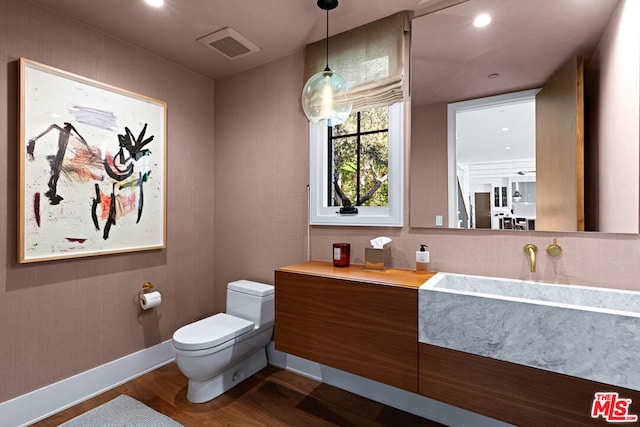 bathroom featuring wood-type flooring and toilet