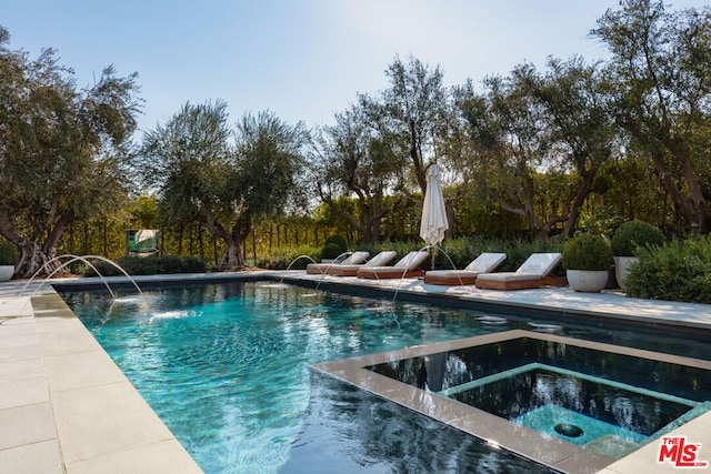 view of swimming pool featuring pool water feature and an in ground hot tub