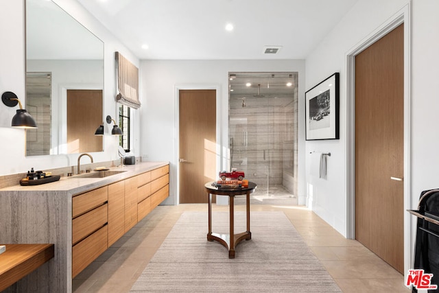 bathroom featuring walk in shower, vanity, and tile patterned flooring