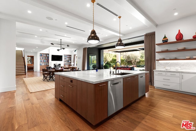 kitchen with beamed ceiling, dishwasher, sink, white cabinets, and a center island with sink