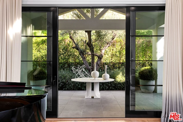 doorway to outside featuring tile patterned flooring and a wealth of natural light