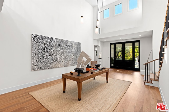 foyer entrance featuring a wealth of natural light, wood-type flooring, and a high ceiling