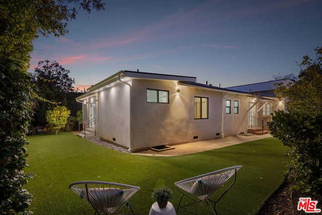 back house at dusk with a yard