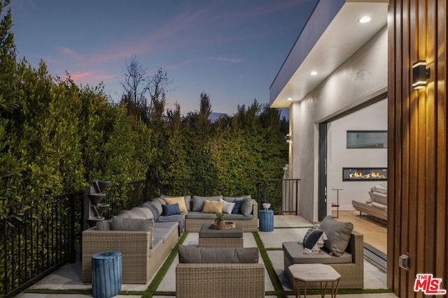 patio terrace at dusk featuring an outdoor hangout area