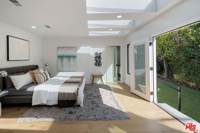 bedroom with a skylight and light hardwood / wood-style floors