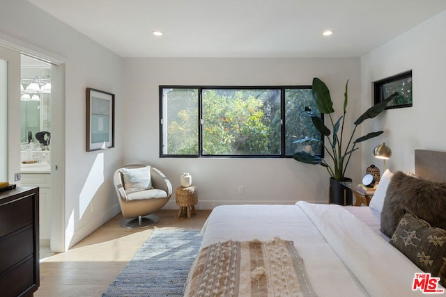 bedroom featuring light hardwood / wood-style floors and ensuite bath