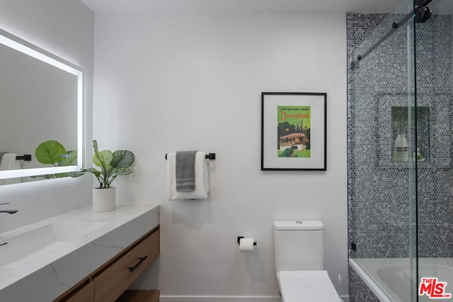 full bathroom featuring tiled shower / bath, vanity, and toilet