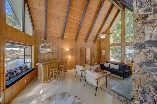 unfurnished living room with wooden walls, beam ceiling, and a wealth of natural light