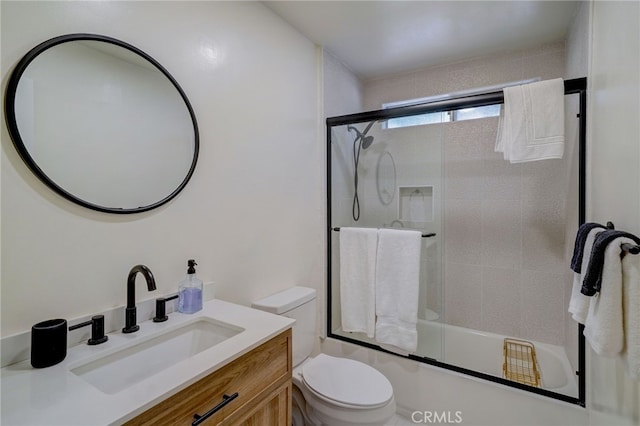 full bathroom featuring enclosed tub / shower combo, vanity, and toilet