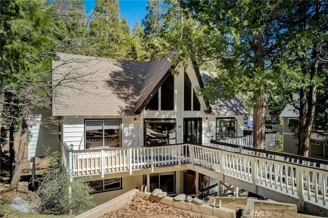 rear view of house featuring a wooden deck