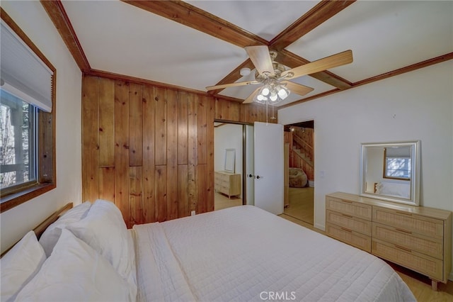 bedroom with crown molding, ceiling fan, and wooden walls