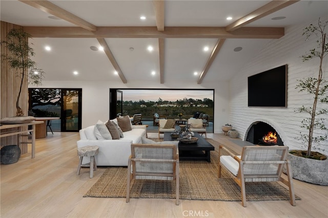 living room with lofted ceiling with beams and light hardwood / wood-style floors