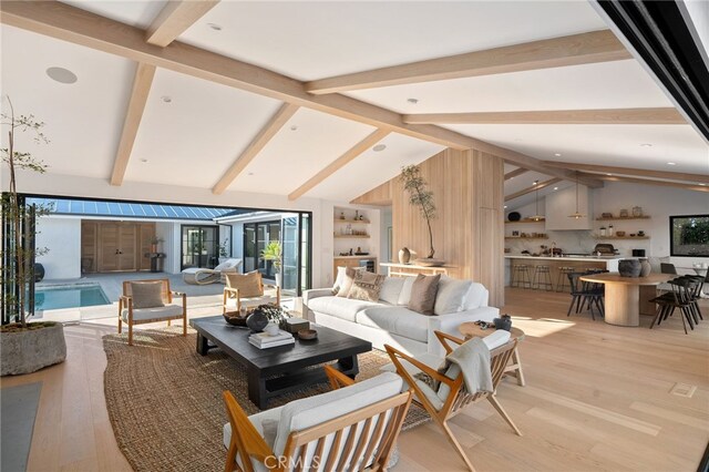 living room with lofted ceiling with beams and light hardwood / wood-style floors