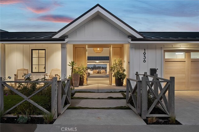 exterior entry at dusk featuring a garage