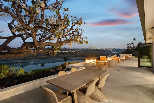 patio terrace at dusk featuring an outdoor living space with a fire pit