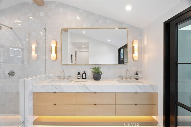 bathroom with vanity, lofted ceiling, an enclosed shower, and decorative backsplash