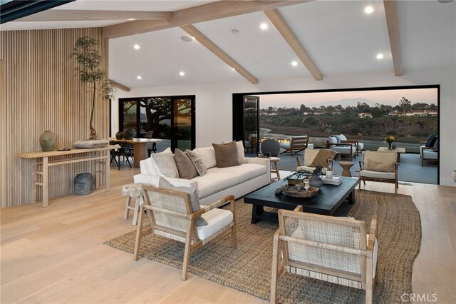 living room featuring vaulted ceiling with beams and light hardwood / wood-style flooring