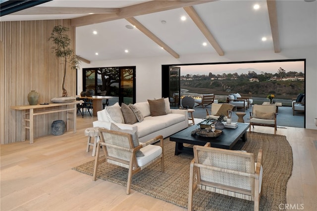 living room with lofted ceiling with beams and light hardwood / wood-style flooring