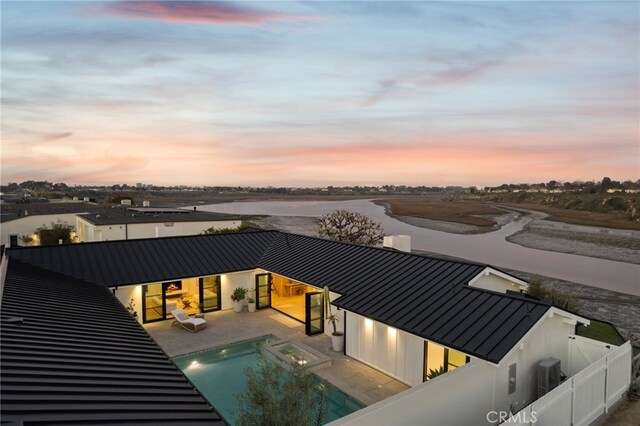 pool at dusk with a patio area