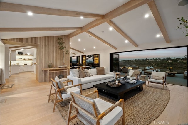 living room with lofted ceiling with beams and light wood-type flooring