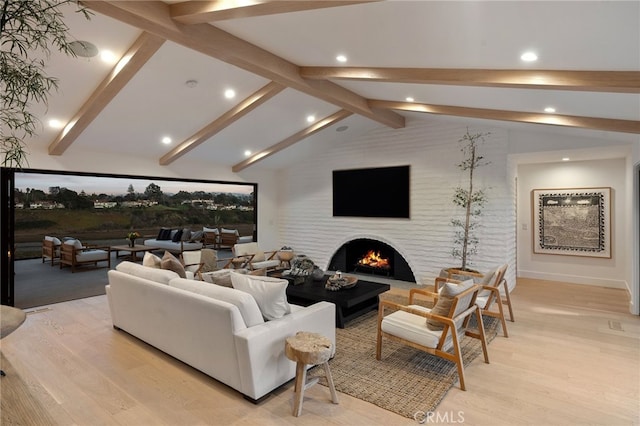 living room with lofted ceiling with beams and light hardwood / wood-style flooring