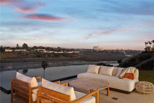 patio terrace at dusk featuring an outdoor hangout area