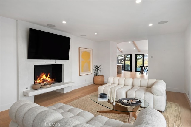 living room featuring vaulted ceiling and light hardwood / wood-style flooring