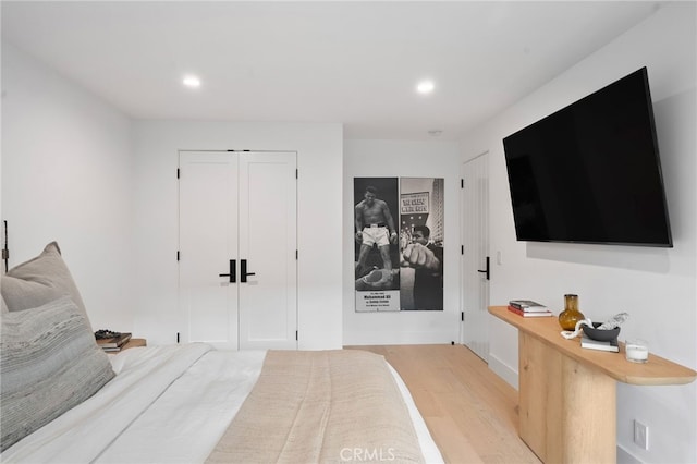 bedroom featuring light hardwood / wood-style flooring and two closets