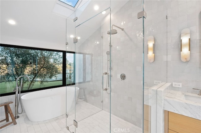 bathroom with vanity, a skylight, and separate shower and tub