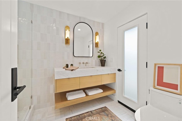 bathroom with walk in shower, vanity, tile walls, and backsplash