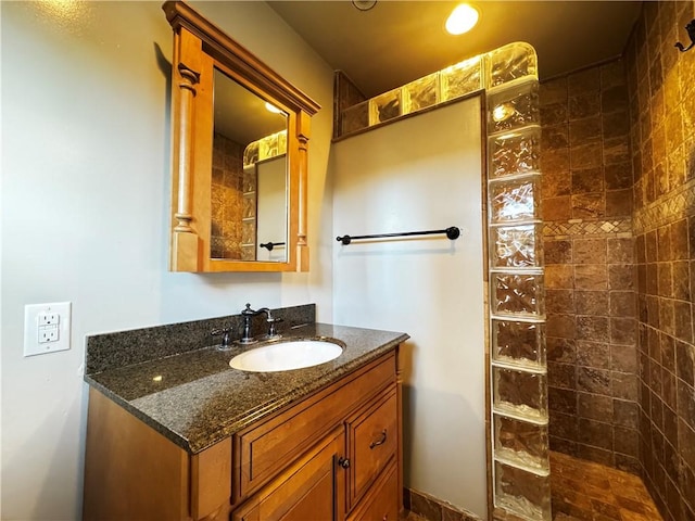 bathroom with vanity and tiled shower