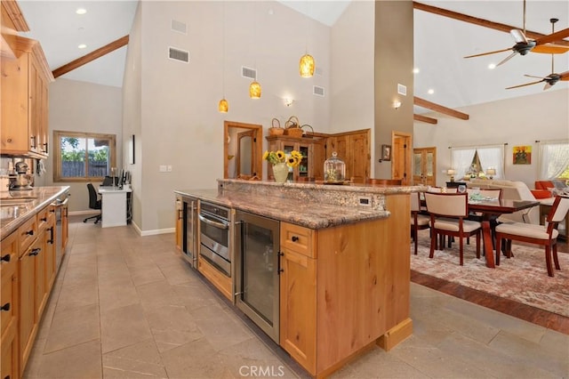 kitchen with ceiling fan, stone counters, wine cooler, decorative light fixtures, and oven